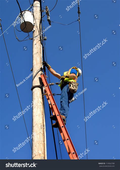 Lineman Climbs Utility Pole To Fix Problem He Is Standing On A Ladder