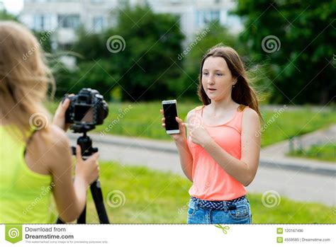 In The Summer In The City On The Street Two Girlfriends Girl Writes The Video To Camera The