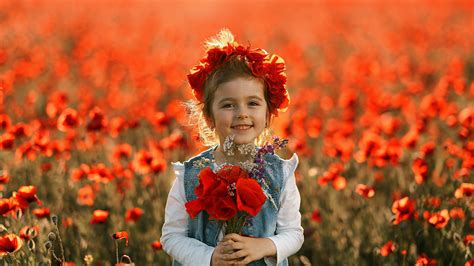Beautiful Smiling Of Girl Child With Shallow Background Of Red Flowers