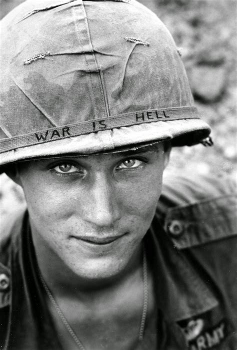 an american soldier wears a hand lettered “war is hell” slogan on his helmet vietnam 1965