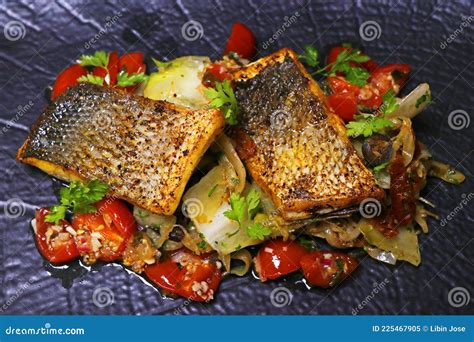 Pan Fried Sea Bass Fillet With Mediterranean Style Sauteed Fennel Chicory And Cherry Tomato
