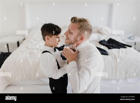 Smiling Father And Son Getting Dressed For Wedding In Bedroom Stock Photo Alamy