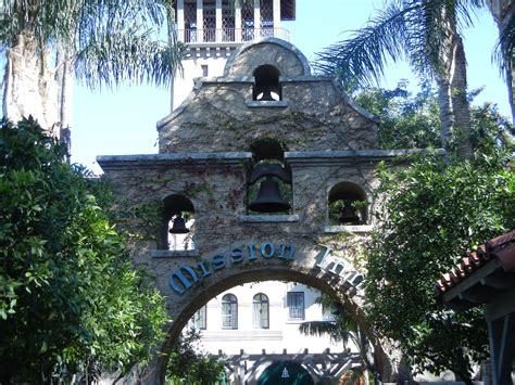 An Old Stone Building With A Bell Tower On Top And Palm Trees In Front