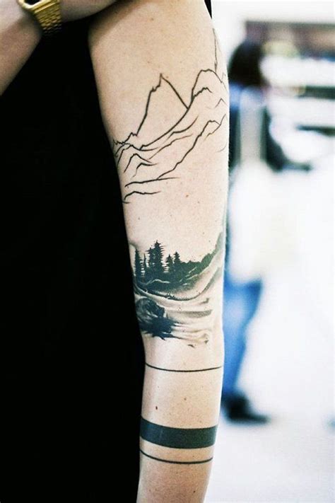 A Man With A Mountain Tattoo On His Arm