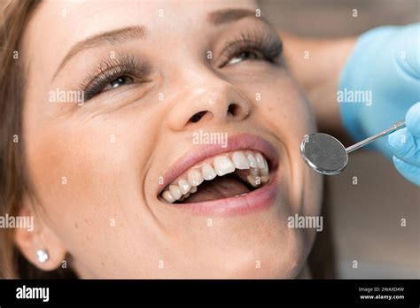 The dentist carefully works on the patient's smile, creating the