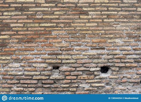 Background Of Old Dirty Brick Wall With Peeling Plaster Stock Photo