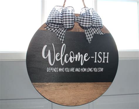 A Welcome Sign Hanging From The Side Of A Door With Gingham Bows On It