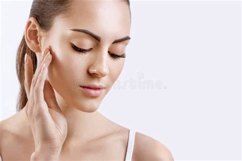 Young Woman Applying Cream To Her Face Skincare And Cosmetics Concept