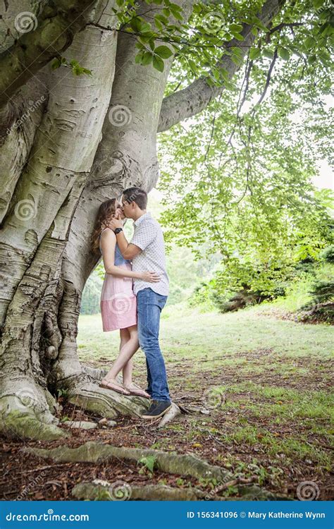 Couple Kissing Under A Tree Stock Photo Image Of Secret Hugging
