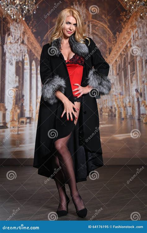 fashion seductive blond hair lady in an elegant fur coat red lingerie and stockings stock image