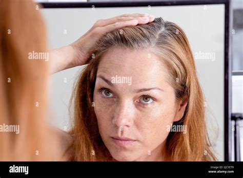 Gray Haired Caucasian Middle Aged Woman Looking At Grey Hair Head In Mirror Reflection Stock