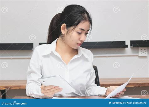 Attractive Young Asian Businesswoman Working On The Workplace In Office