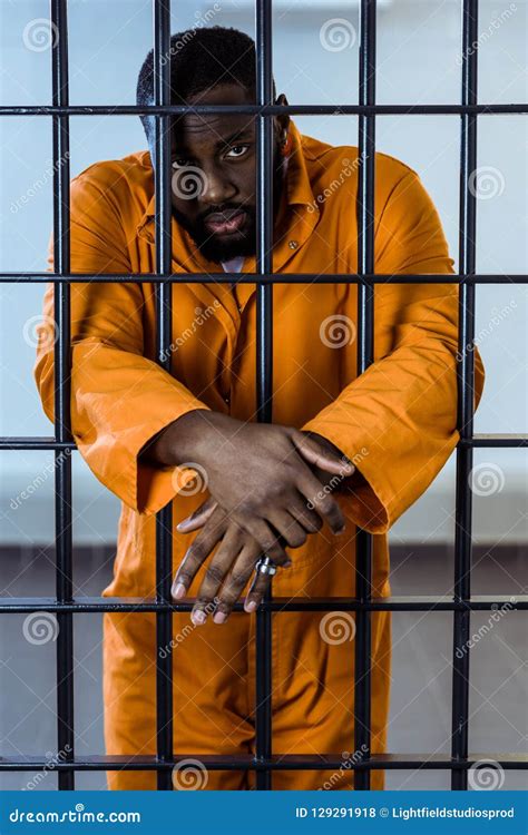 African American Prisoner In Uniform Standing Behind Stock Photo