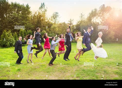 Full Length Portrait Of Newlywed Couple With Bridesmaids And Groomsmen