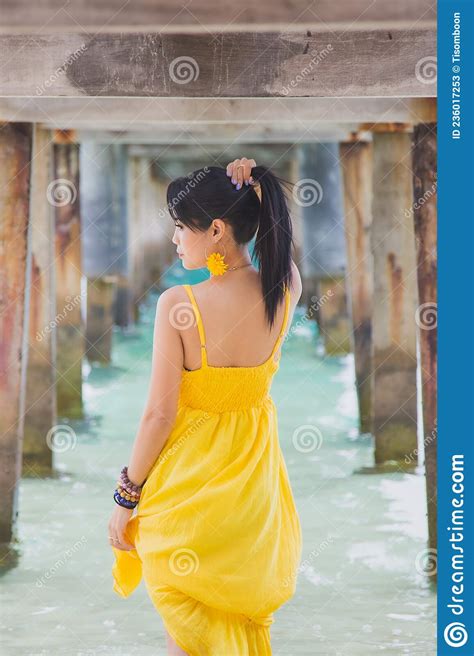 Portrait Beautiful Asian Woman In A Yellow Dress Standing Under The