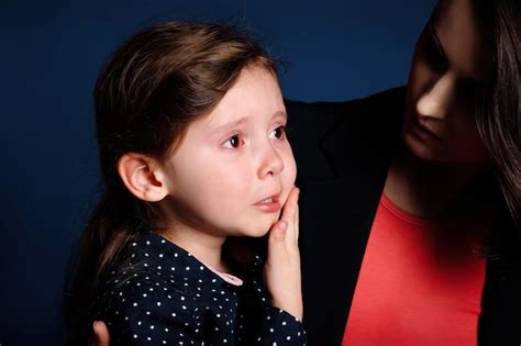 La Niña Está Molesta Y Llora De Resentimiento En Los Brazos De Su Madre