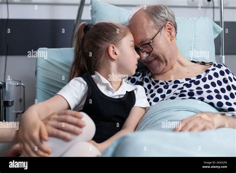 Elderly Recovering Patient Happily Cuddling Infant Granddaughter In