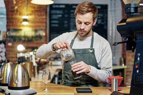 Male Barista Pouring Coffee At Coffee Shop Kitchen Counter Stock