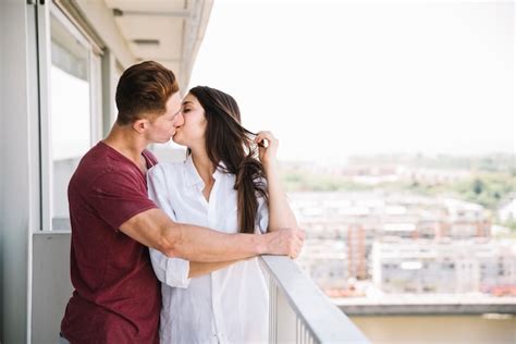 Mann Der Frau Auf Balkon Umarmt Und Küsst Kostenlose Foto