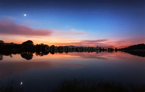 Mountain Lake With Stars And Reflected Clouds In Water Night Stock