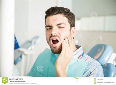 Male Patient Suffering From Toothache In Dental Clinic Stock Photo