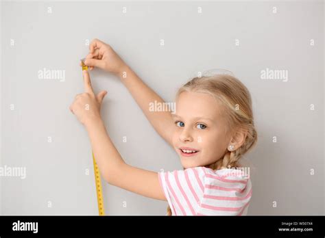 Cute Little Girl Measuring Height Near Wall Stock Photo Alamy