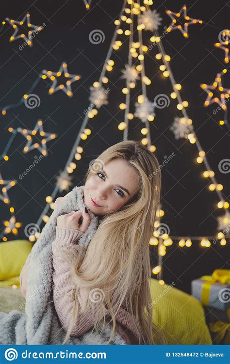 Young Woman In A Plaid Posing Against The Background Of Christmas