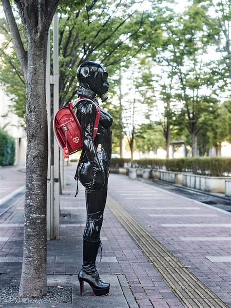 Black Rubber Latex Clothing With Red Randoseru In Public A Photo On