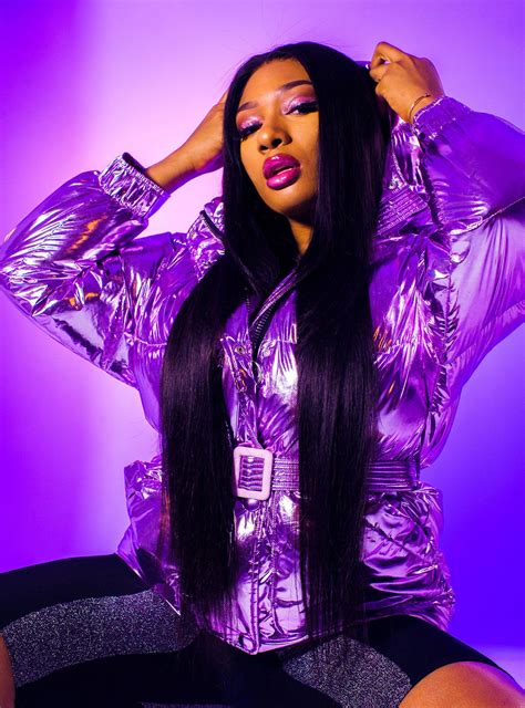 A Woman With Long Black Hair Sitting On The Ground Wearing Shiny Purple Clothing And Holding Her