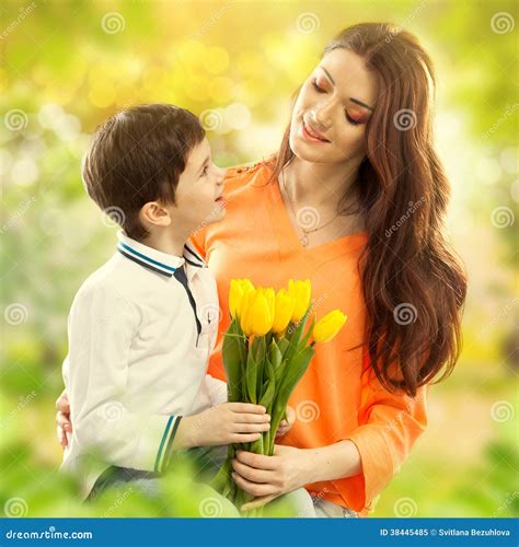 El Hijo Que Abraza A Su Madre Y Le Da Las Flores Imagen De Archivo