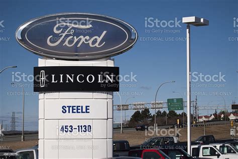 Ford And Lincoln Dealership Sign Against Clear Sky Stock Photo