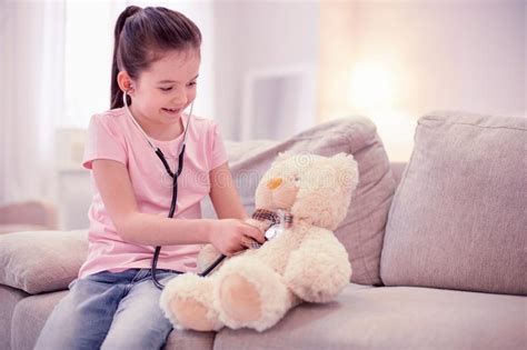 Dark Haired Cute Girl Wearing Jeans And Pink Shirt Playing With Teddy