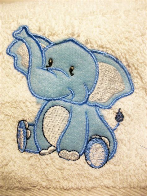 An Elephant Embroidered Onto The Side Of A White Towel With Blue