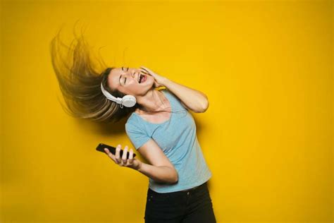 🥇 Image Of Woman Listening To Music With Headphones On Yellow