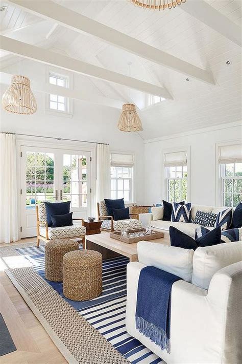 A Living Room Filled With White Furniture And Blue Pillows On Top Of A