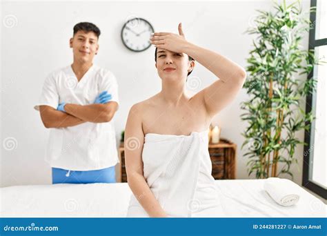 Young Woman At Wellness Spa With Professional Therapist Sitting On Massage Table Stressed And