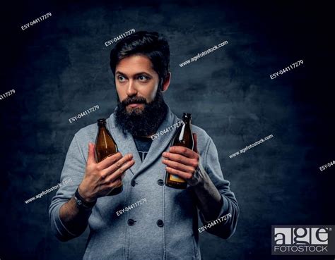 Full Throttle Bearded Male Holds Two Craft Beer Bottles Stock Photo