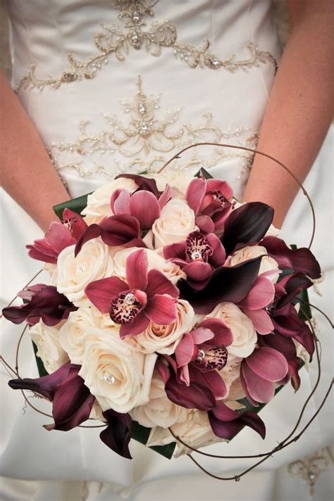 Pretty Wine Colored Bouquet Gems Centered On Roses And Orchids With
