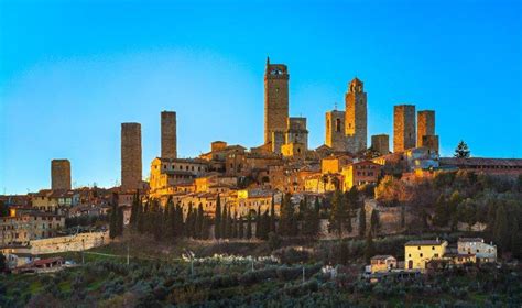san gimignano town skyline and medieval towers sunset in blue hour italian olive trees in