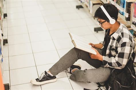 Premium Photo Young Student Sitting On The Floor Reading A Book By