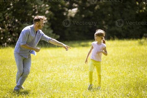 Father Chasing His Little Daughter While Playing In The Park 2879431