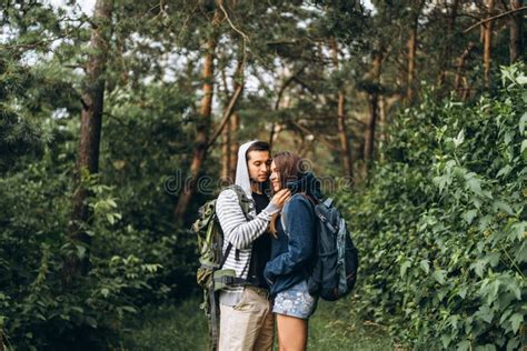 Young Couple With Backpacks On Their Backs In The Forest Loving Man