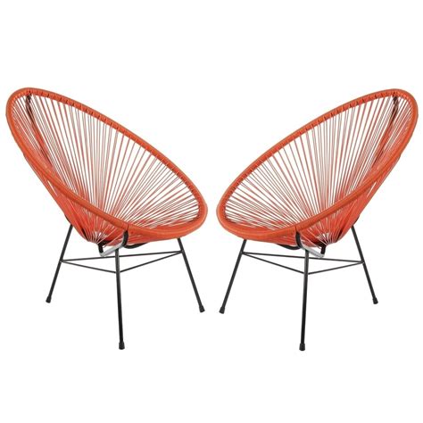 Two Orange Chairs Sitting Next To Each Other On Top Of A White Surface