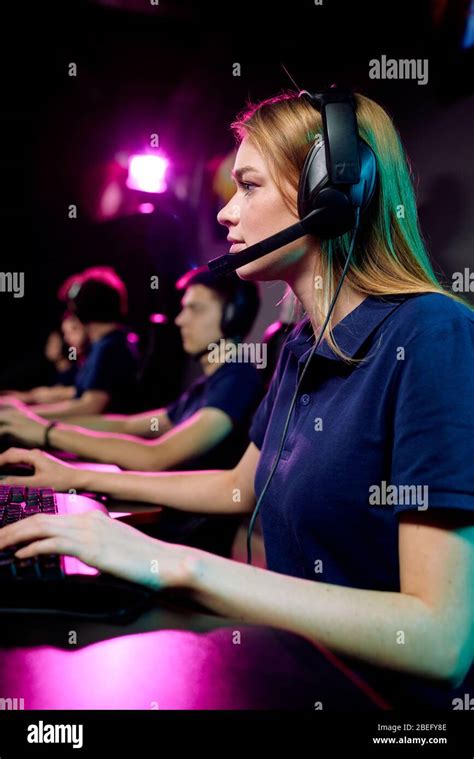 Focused Young Female Computer Gamer In Hands Free Headset With