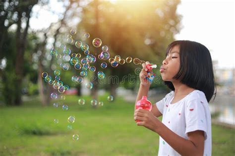 A Little Girl Blowing Soap Bubbles In Summer Park Stock Image Image