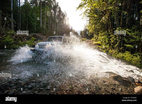 4x4 SUV Jeep Driving Through River In British Columbia Stock Photo