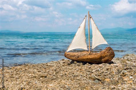 Miniature White And Blue Wooden Boat With Anchor Lay On Sand Sailer