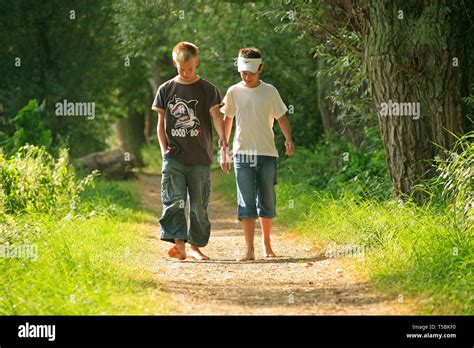 Barefoot Boys Walking Along A Forest Path Stock Photo Alamy