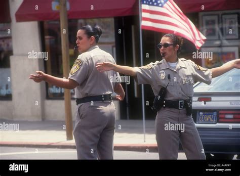 two female hispanic police officers direct traffic in san diego ca american flag in the