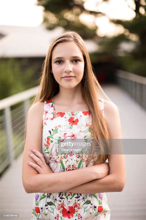 Headshot Of Beautiful Teenage Girl On Bridge With Arms Crossed High Res
